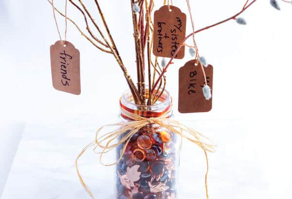 A stylish vase with twigs & tags highlighting a unique & natural decorative element