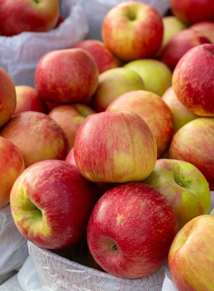 Fresh red and yellow apples stacked in baskets at a market in Ann Arbor, MI